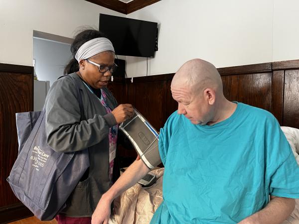 Community health nurse taking client's blood pressure